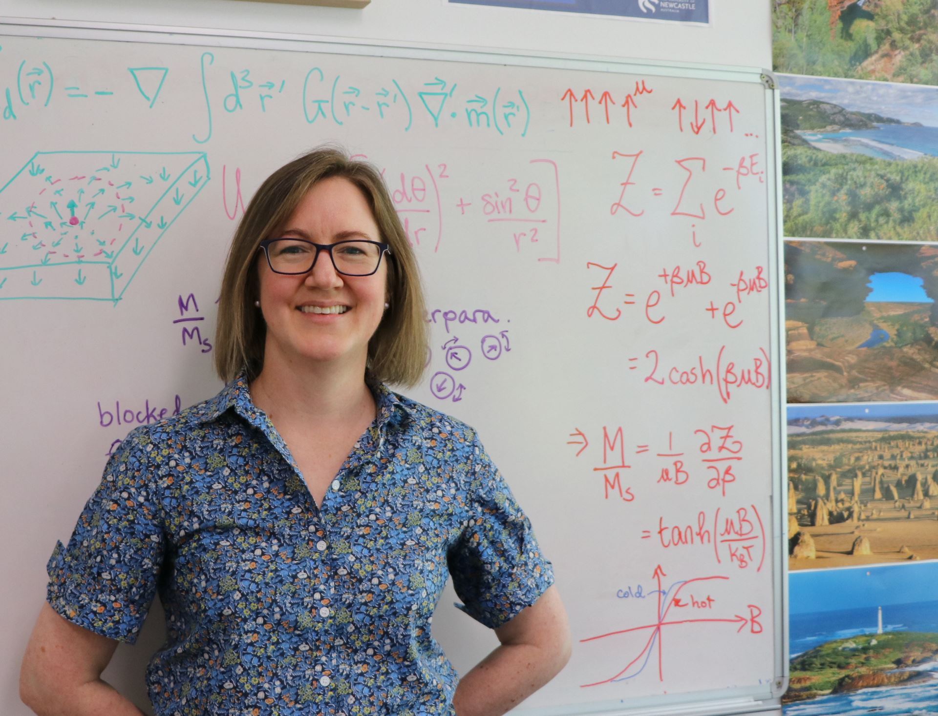 Dr Karen Livesey standing in front of a whiteboard, which is covered in physics equations